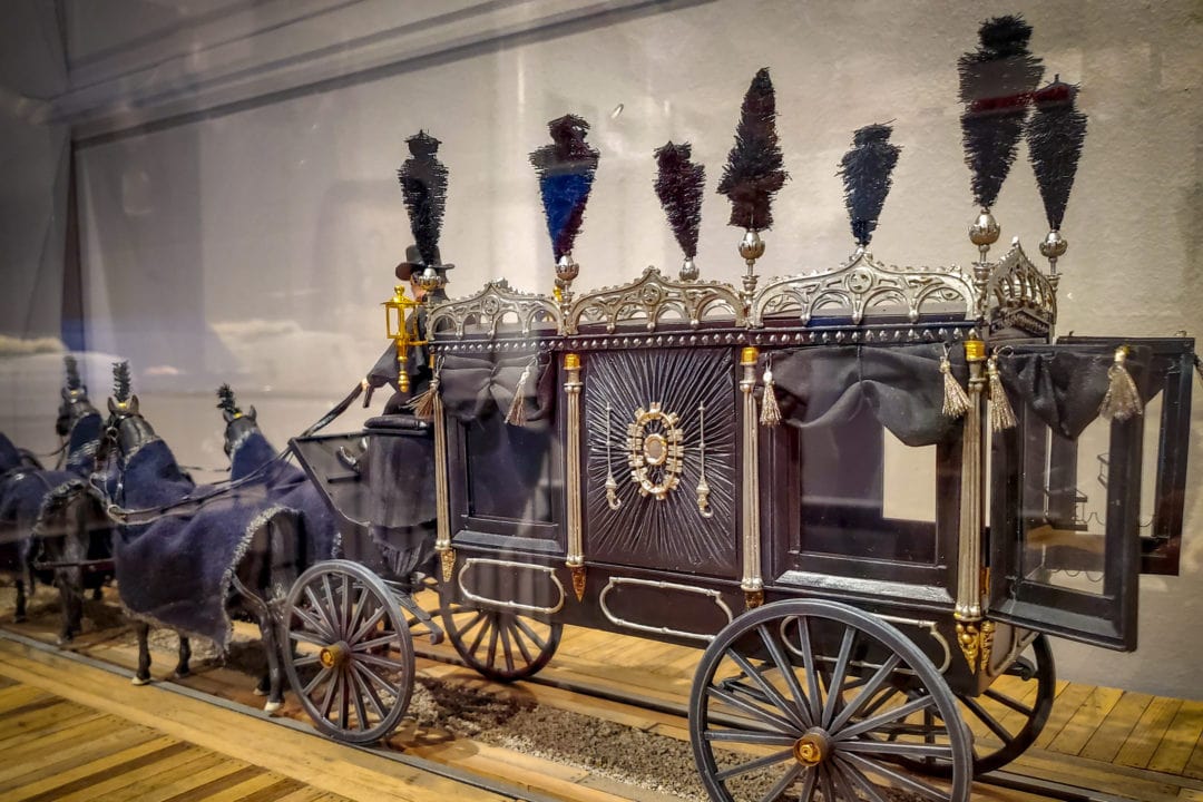 Replica of a horse drawn hearse with feather plumes.
