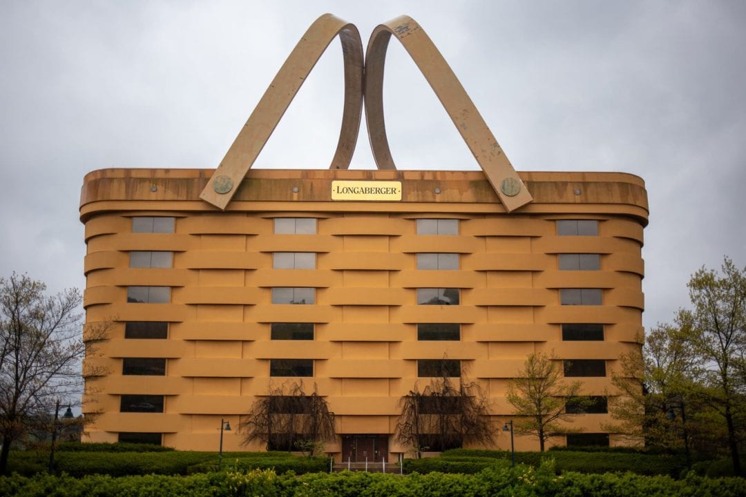The Longaberger Basket headquarters, a giant building shaped like a basket, against a gloomy sky.
