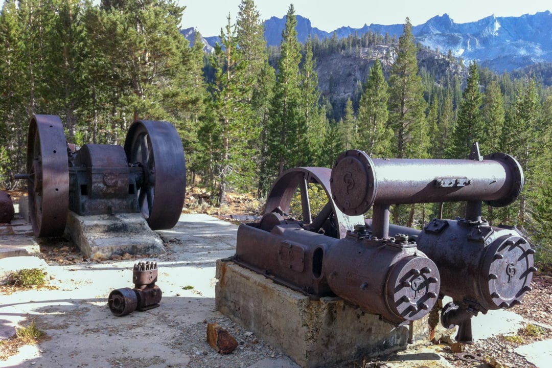 Rusted machinery leftover from a mine set into the pine trees