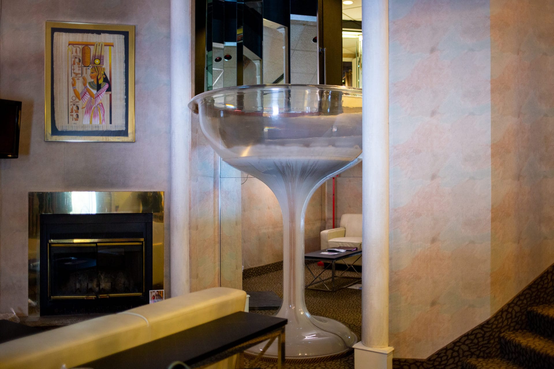 A two-story hotel room with a 7-foot-tall champagne glass-shaped bathtub in the center.