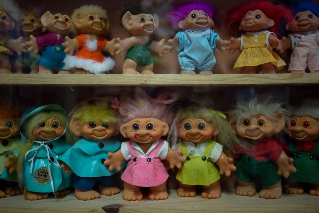 Several troll dolls on shelves