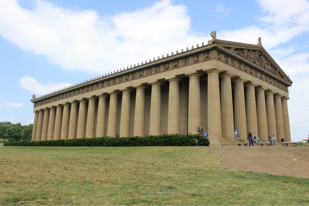 A full-size replica of the Parthenon temple in Greece, surrounded by greenery 