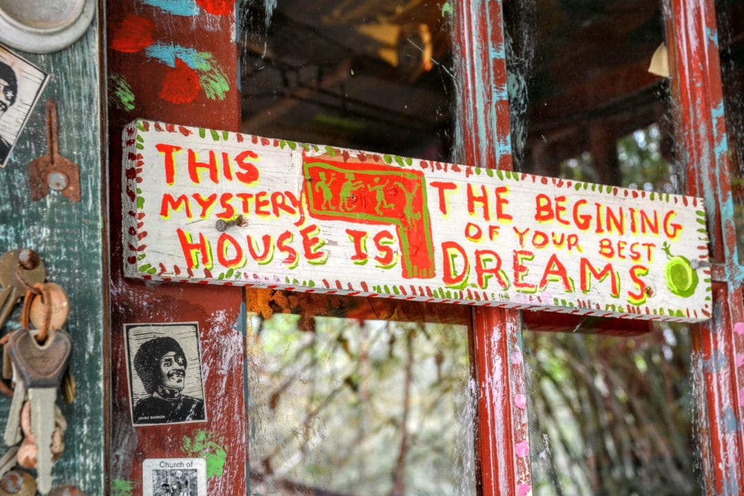 a handpainted sign that says "this mystery house is the beginning of your best dreams"