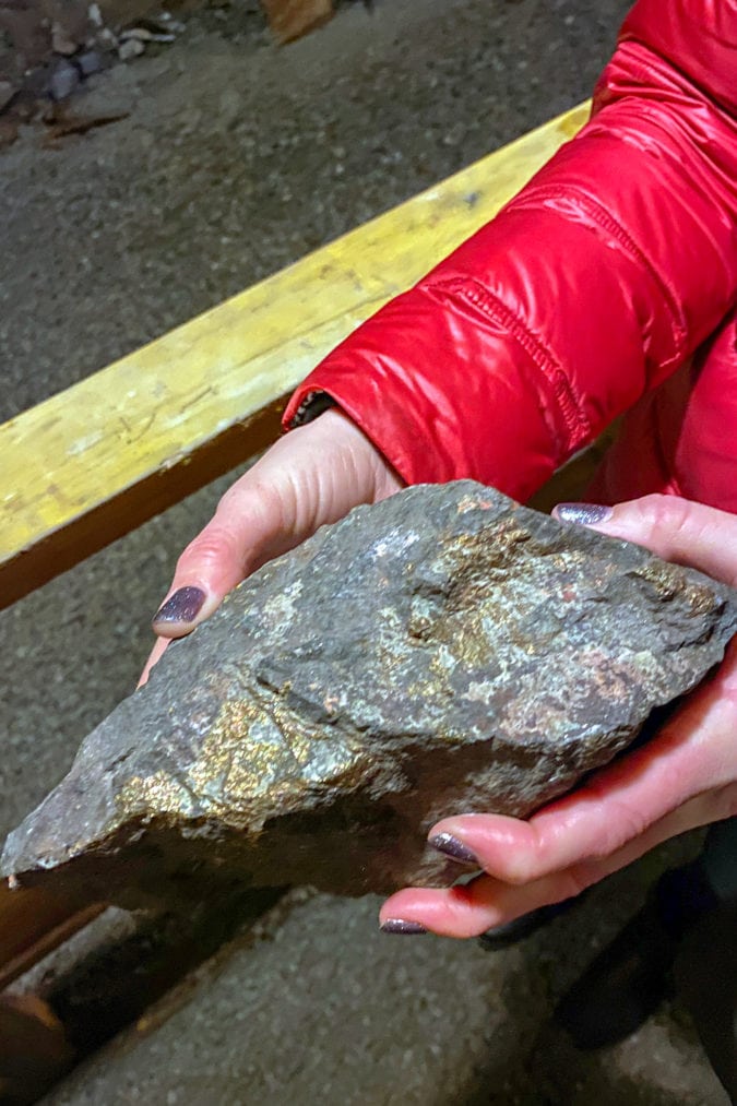 A woman holds a large shiny rock