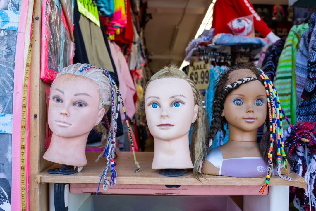 Three mannequin heads with colorful braids 
