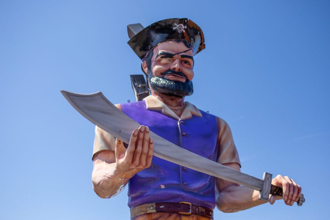 A pirate-themed Muffler Man against a blue sky