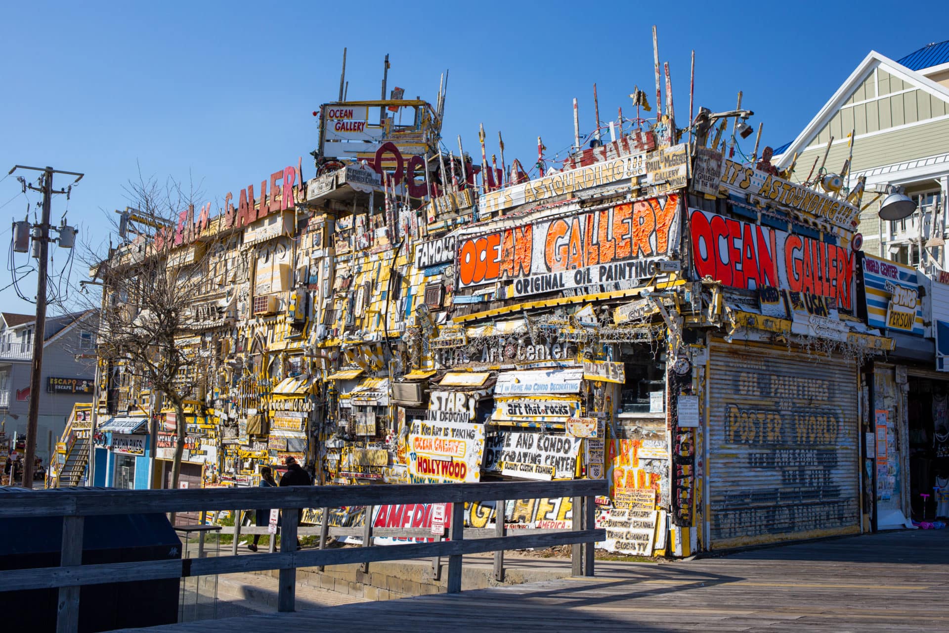 A chaotic boardwalk storefront completely covered in found objects and hand-painted signs