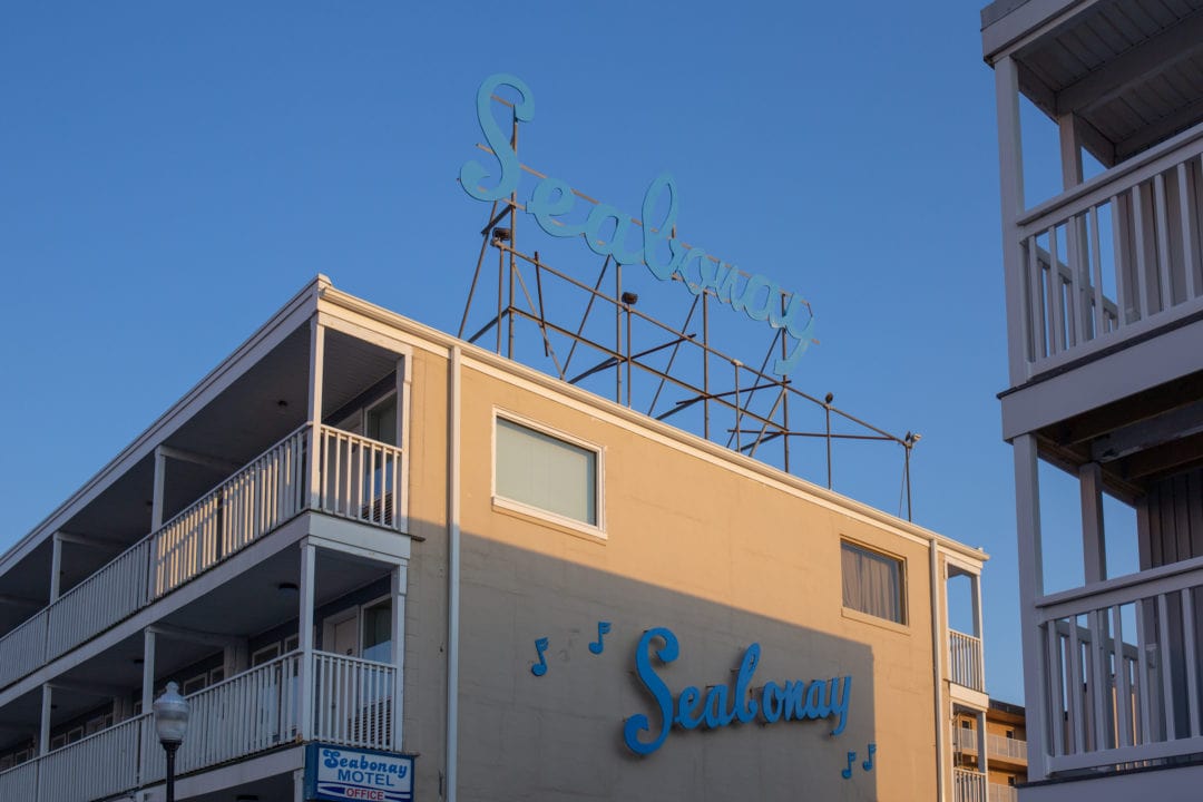 a beach hotel with a blue sign that says "seabonay" in script