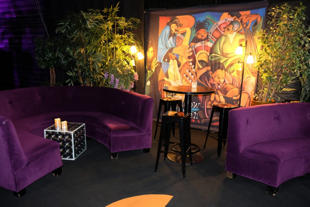 purple velvet couches and a mural depicting jazz musicians