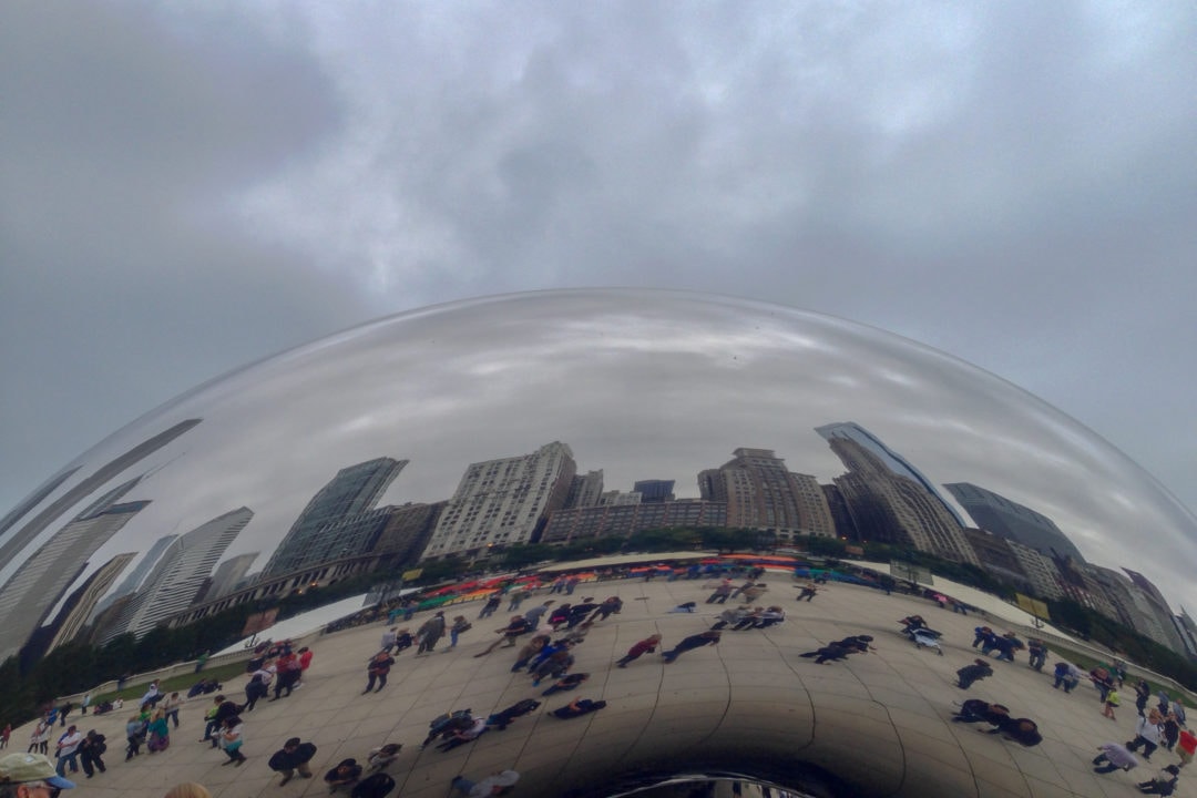 A large, reflective bean-shaped sculpture reflecting the Chicago skyline