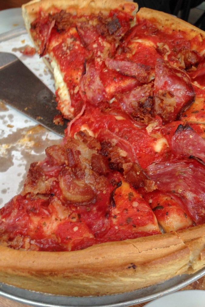 a deep dish pizza topped with bacon and ham