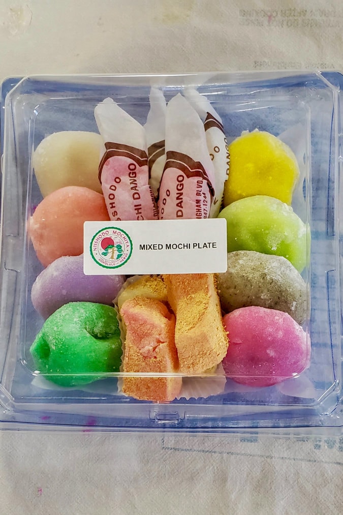 a plastic container full of colorful mochi