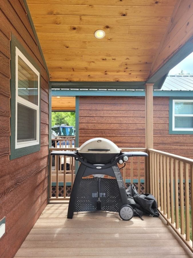 View from a covered porch looking out the balcony with a gas grill on the porch