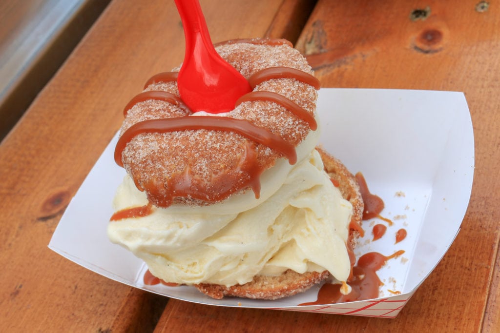 an apple cider donut stuffed with vanilla frozen custard and topped with caramel