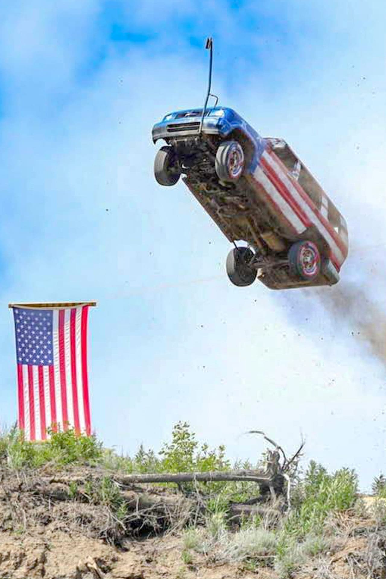 a car painted like an american flag is launched into the air next to an american flag