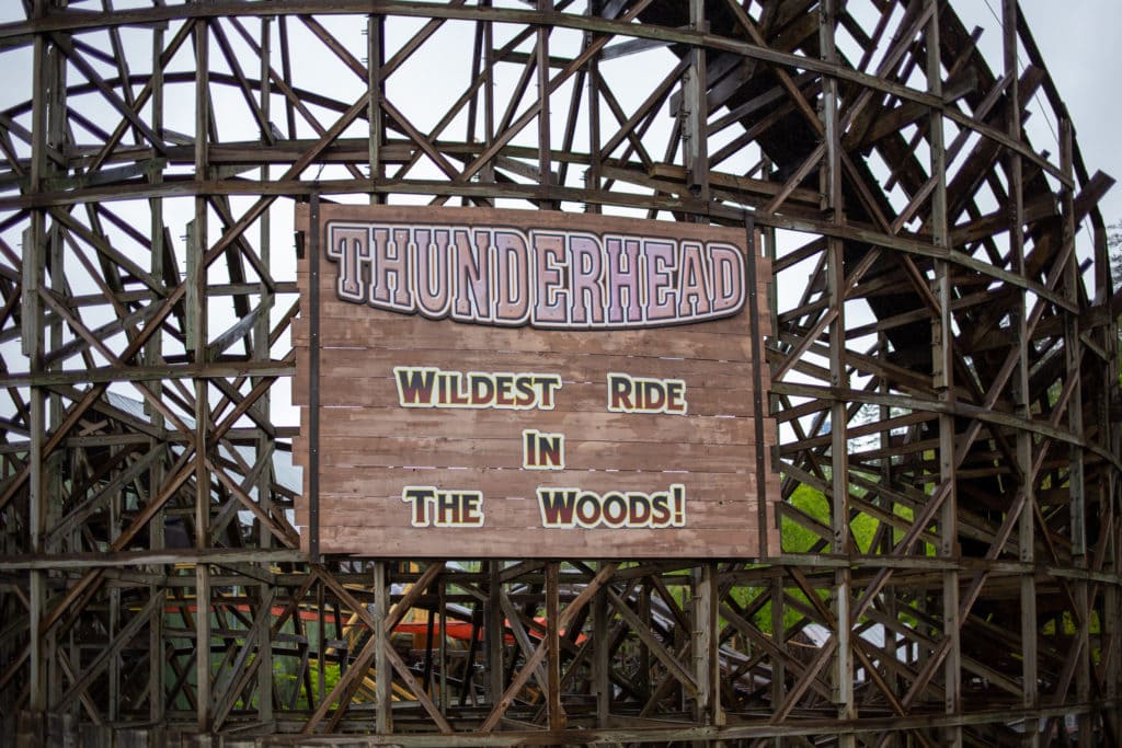 a wooden rollercoaster with a sign that says "thunderhead, wildest ride in the woods!"
