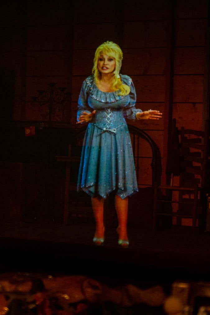 a hologram of dolly parton is projected onto a dark stage