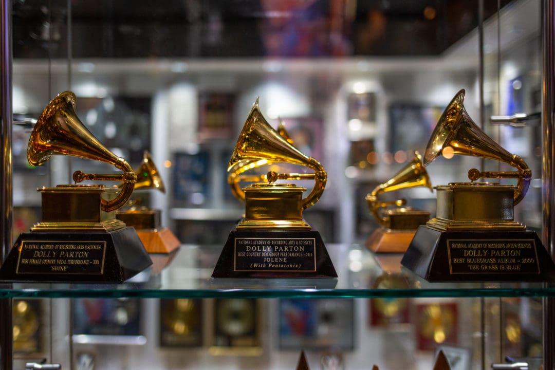 three grammy awards on a display shelf