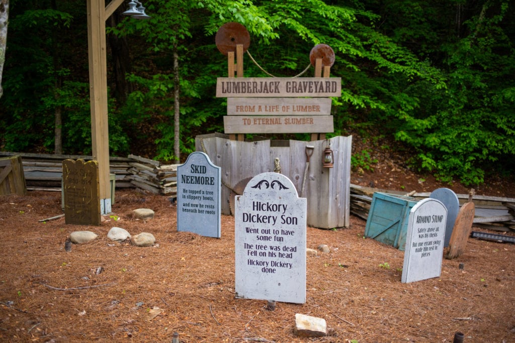 fake tombstones with joke epitaphs in a lumberjack graveyard