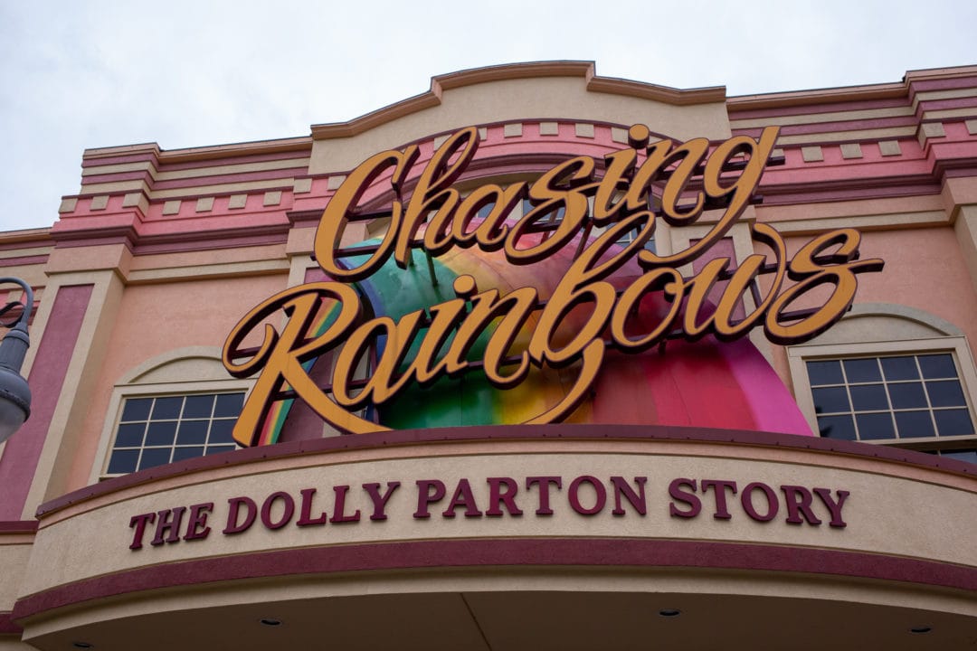 a pink building with a large sign that says "chasing rainbows, the dolly parton story"
