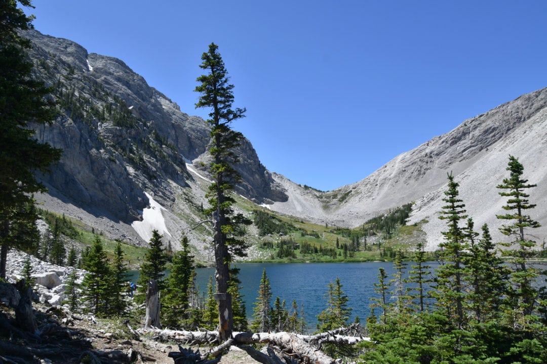 a blue lake surrounded by gray mountains and blue skies