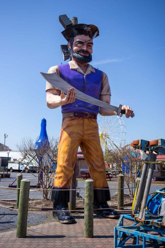 a fiberglass muffler man dressed like a pirate clutching a sword