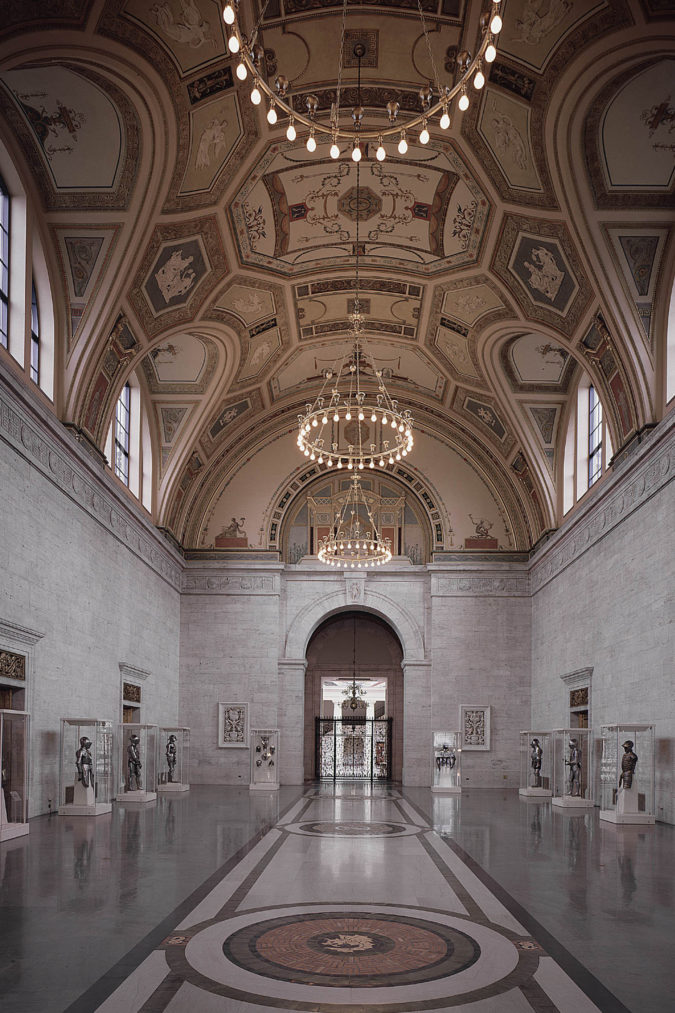 Inside the Grand Hall at the Detroit Institute of Arts lined with suits of armor in cases