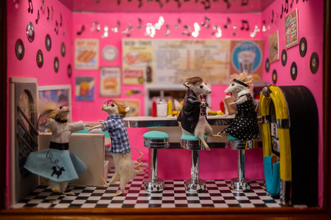 Taxidermy mice are posed in a diorama of a 50s diner
