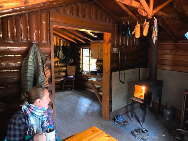 The inside of a log cabin, with a burning wood-fired oven