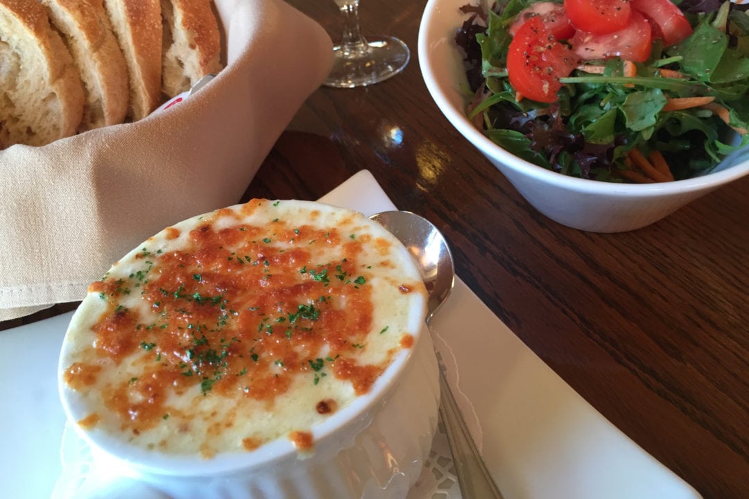 a cheesy crock of chowder, basket of bread and side salad