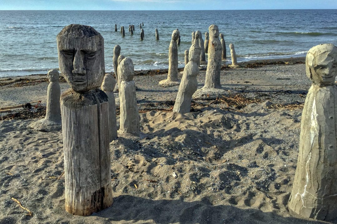 craved human-like sculptures set along the coastline