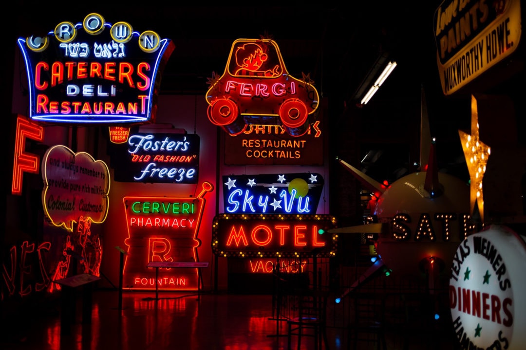 the interior of the american sign museum with a wall full of lit neon signs