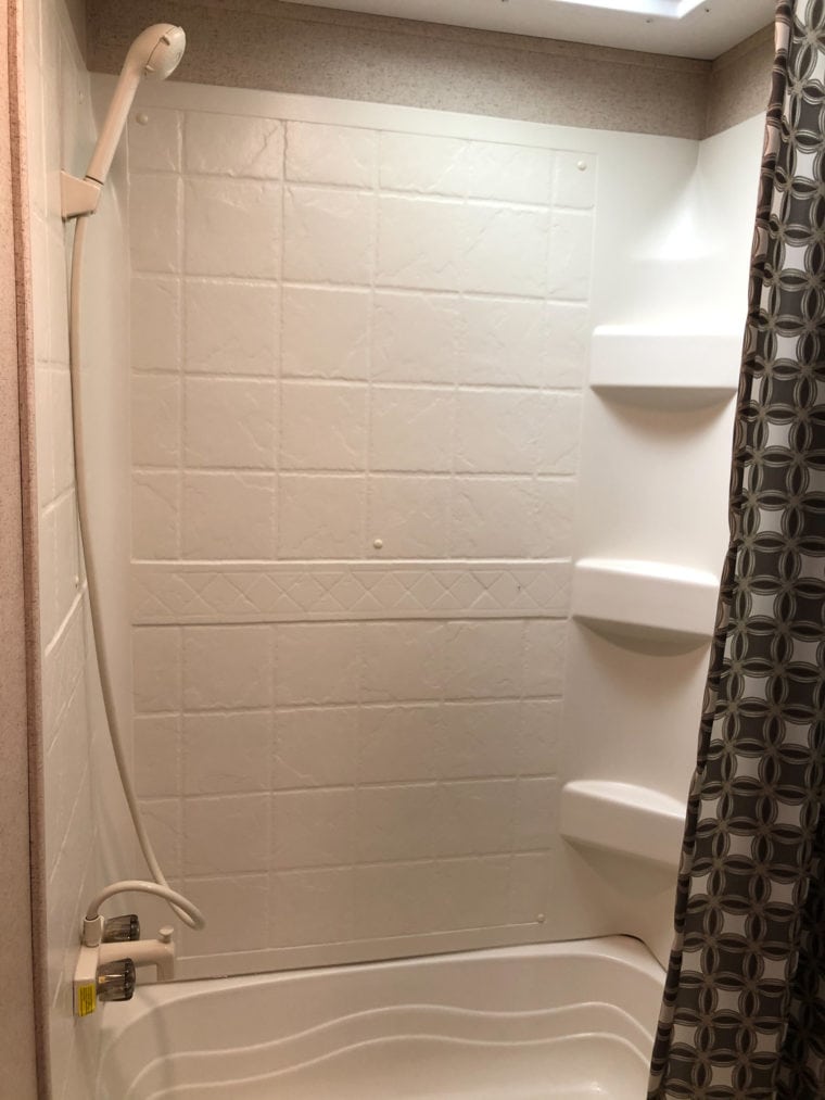 Shower with bathtub and shelving in an RV