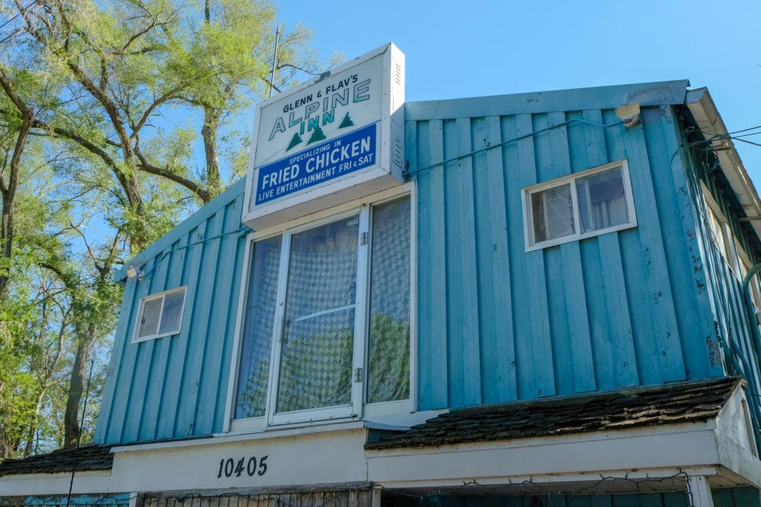 A bright blue building with a sign that says "glenn and flav's alpine inn"