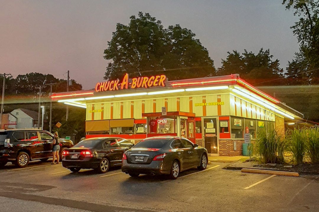 the neon lights of the chuck-a-burger drive-in at night