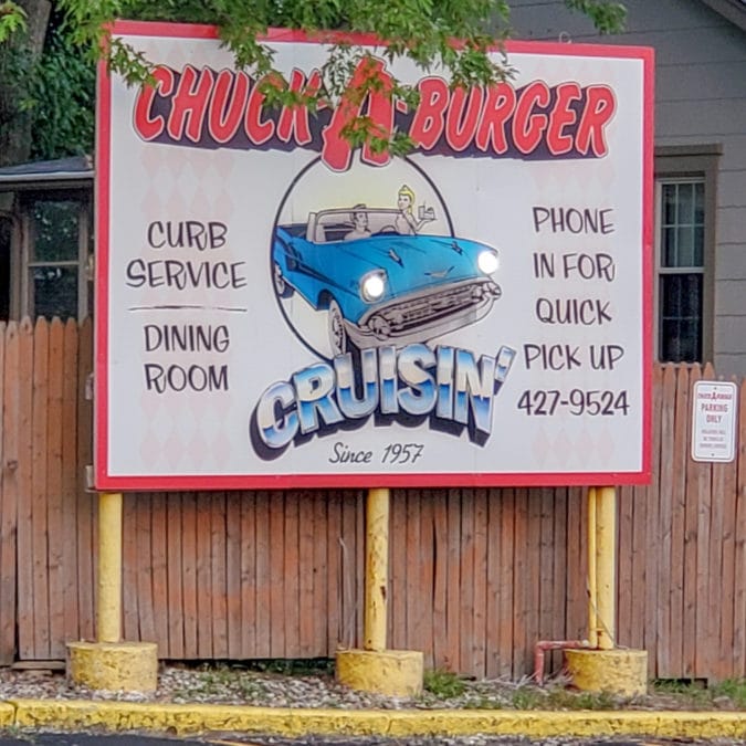 a chuck-a-burger sign featuring an illustration of a classic car with the tagline "cruisin since 1957"