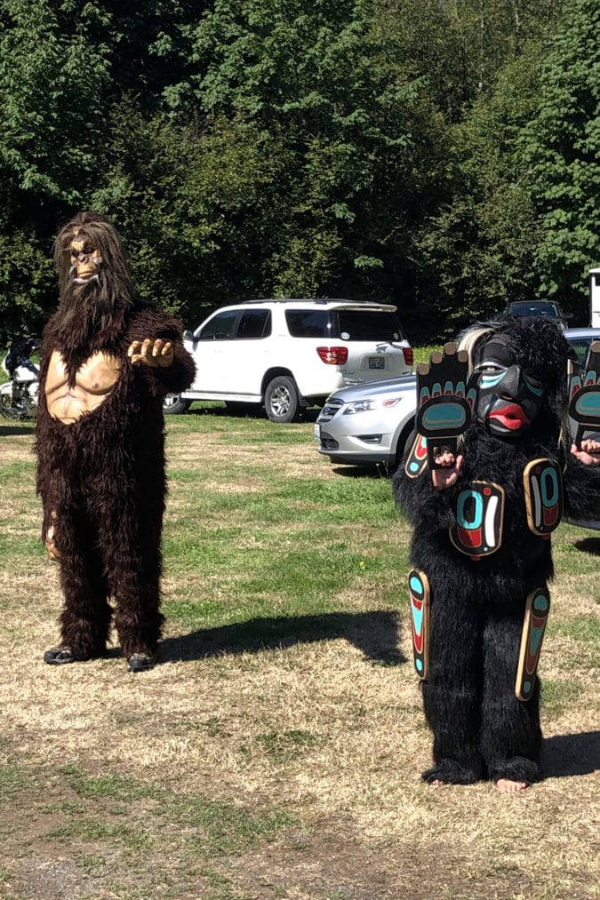 A pair of Sasquatches engage with visitors
