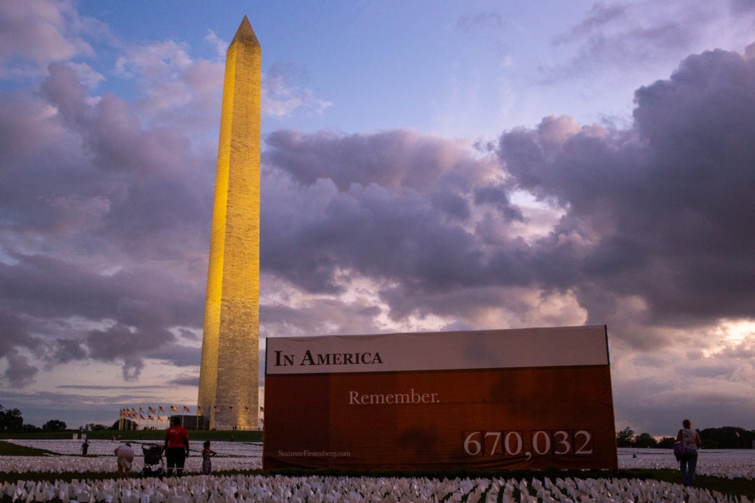 the washington monument and in america remember art installation at sunset