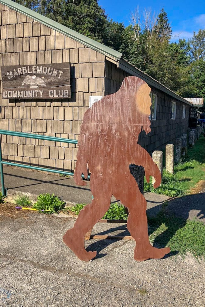 a wooden cutout of bigfoot outside of the marblemount community club