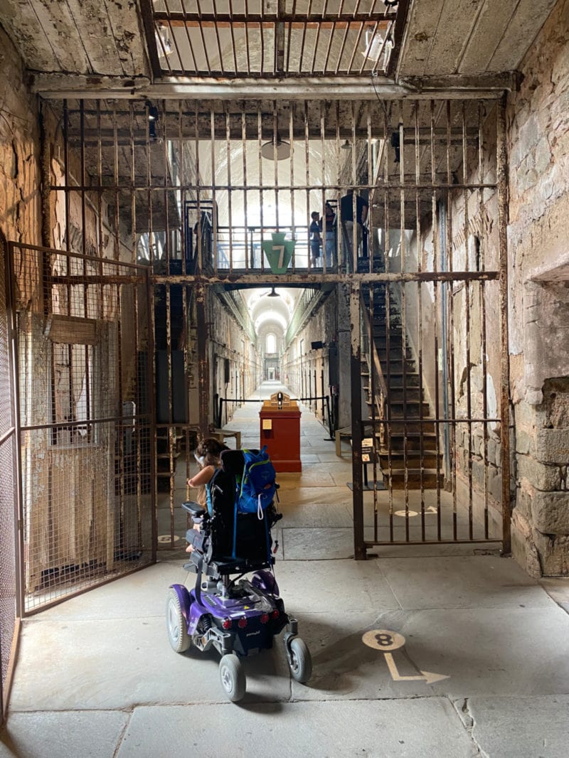 a person in a wheelchair explores an old prison