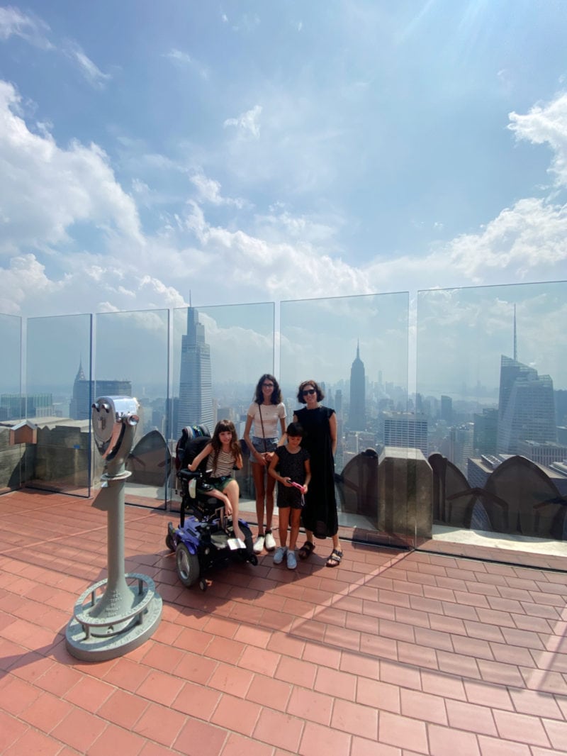 a family of four poses at the top of the rockefeller center observation deck