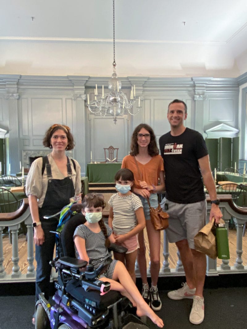 a family of five poses in independence hall