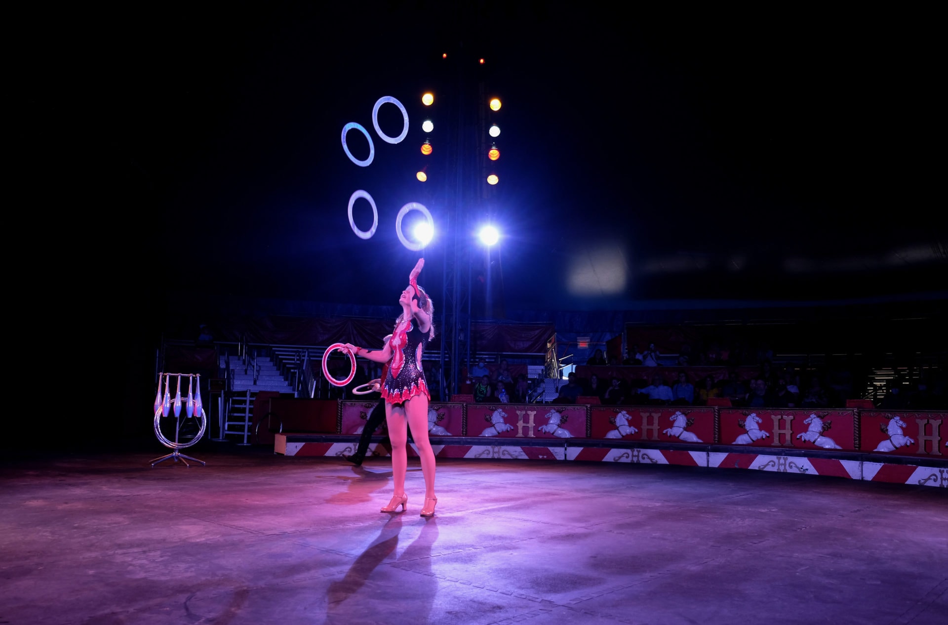 a woman juggles rings in a circus ring