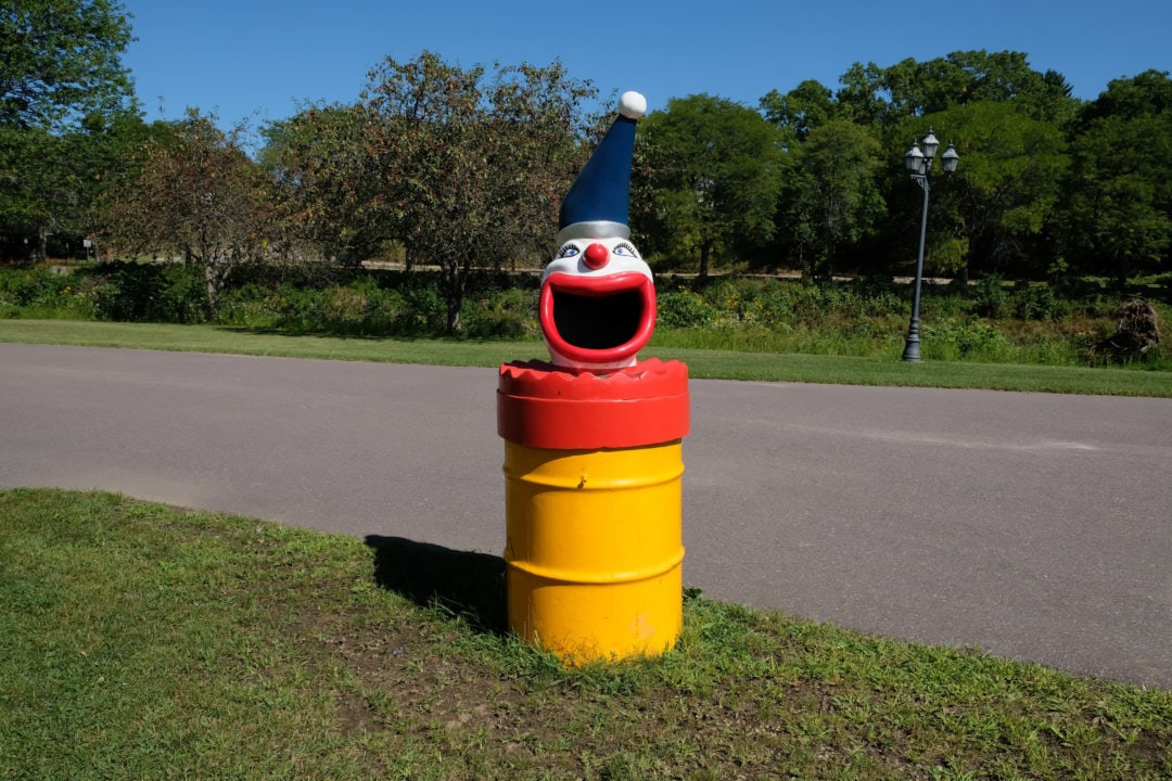 a trash can topped with a clown head