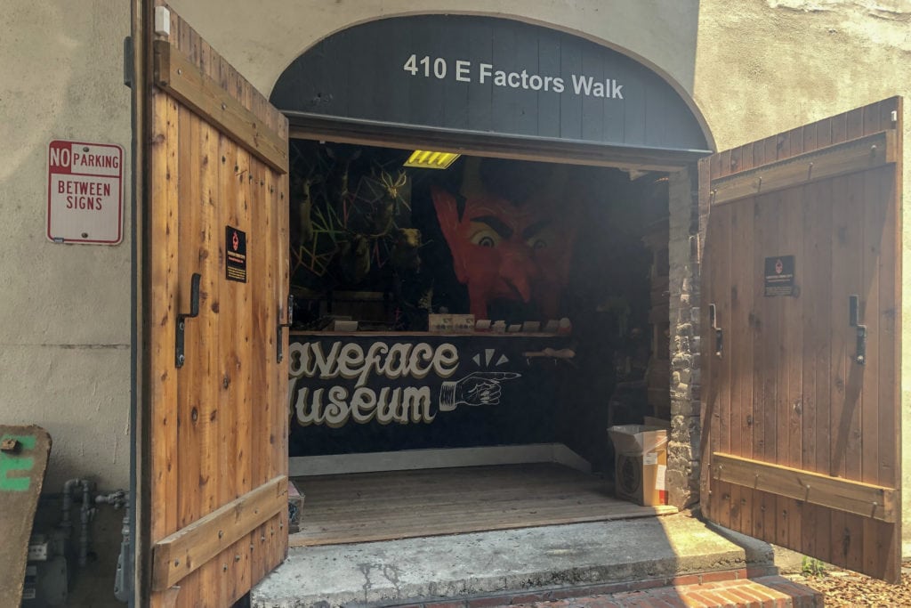 two doors open to a devil-themed entrance that says graveface museum