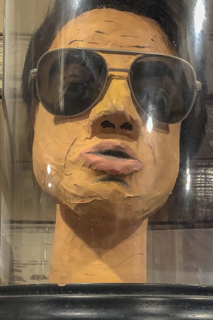 a paper mache bust of jim jones wearing sunglasses