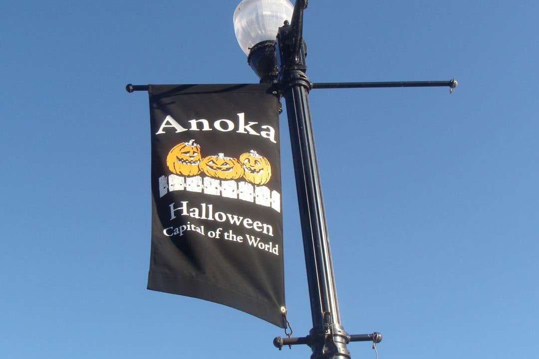a lightpole banner featuring pumpkins that says "anoka, halloween capital of the world"