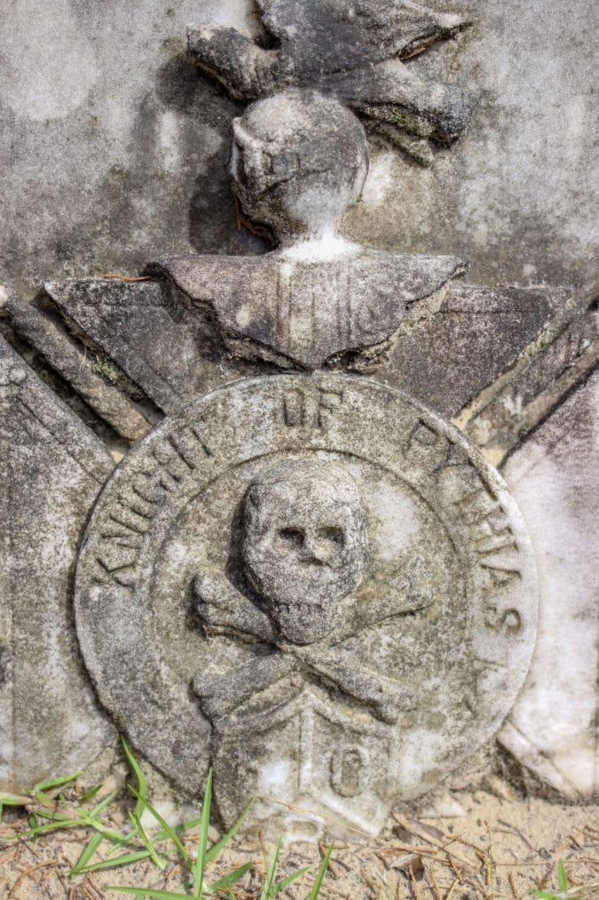 a tombstone featuring a skull and crossbones