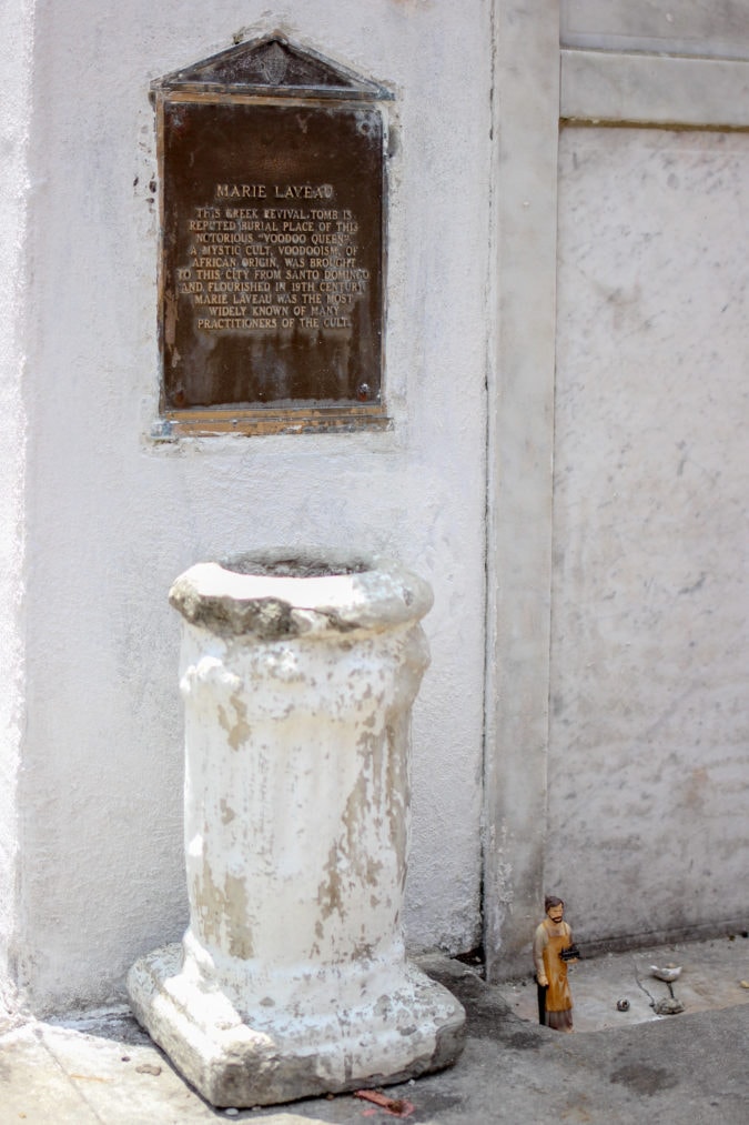 a white mausoleum with a plaque about Marie Laveau