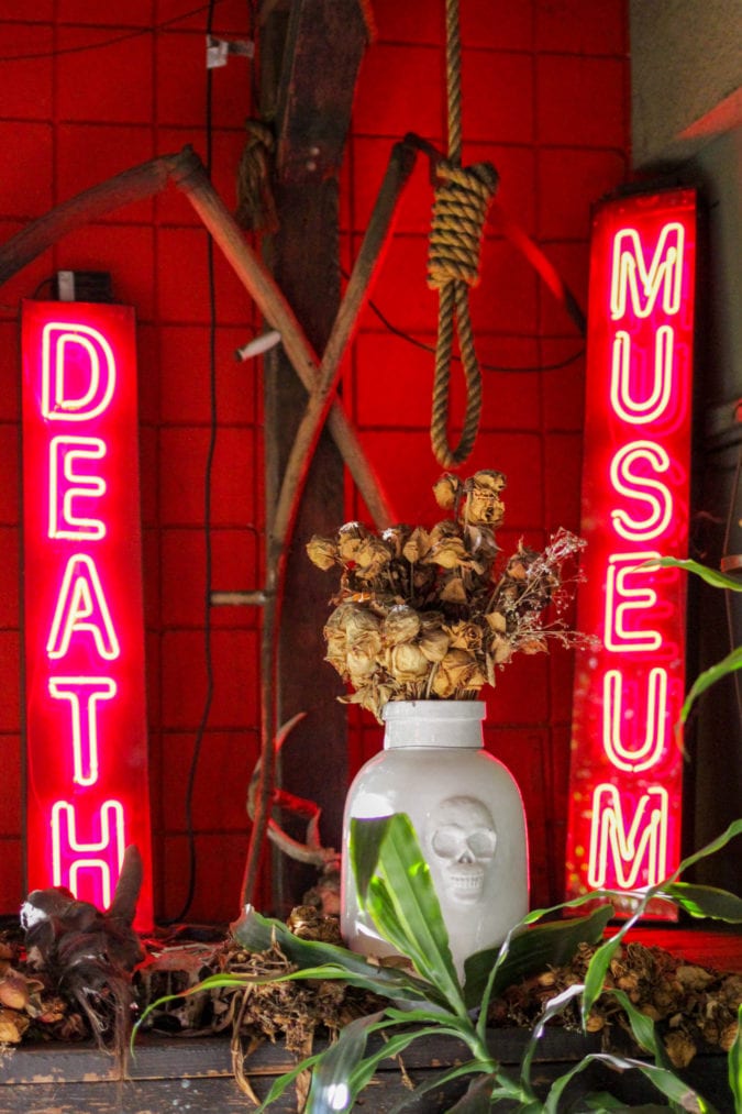 two neon signs that say "death" and "museum" with a noose